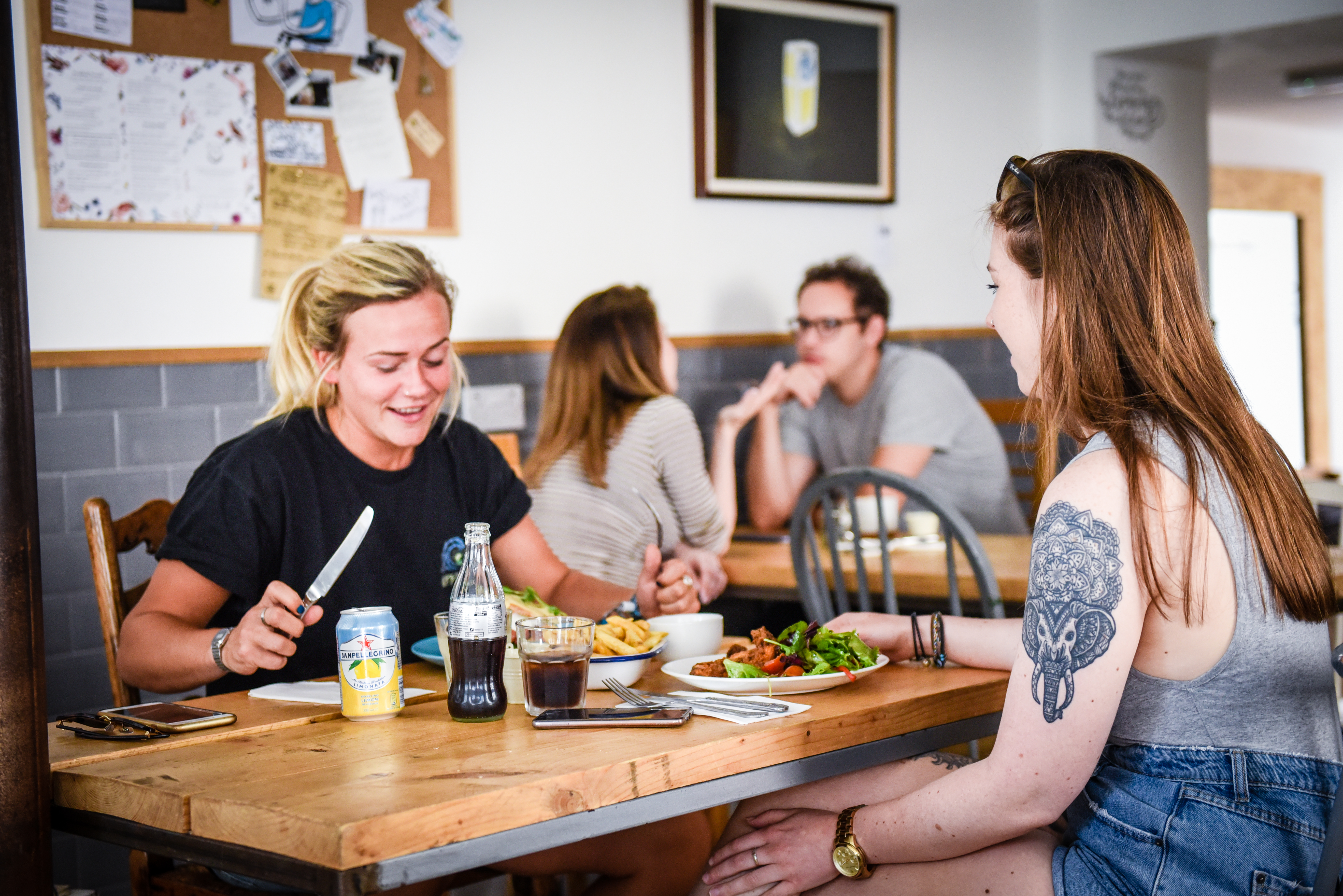 Two women sitting at a table in a cafe eating