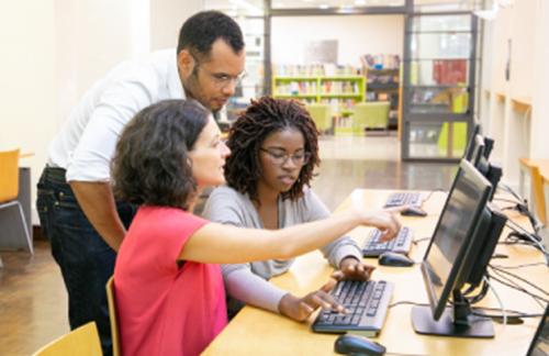 Group Of People Sat Around Talking with a computer 