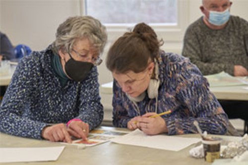 Two over 50s women looking at paperwork together 